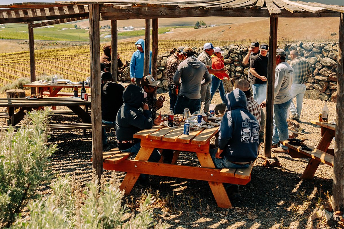 The crew and friends eating and talking under the ramada on the Butte